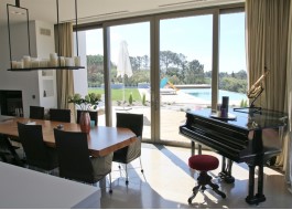White house interior with aluminum sliding door, pool, water slide, piano and wooden table